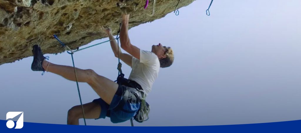 image of a man climbing a cliff