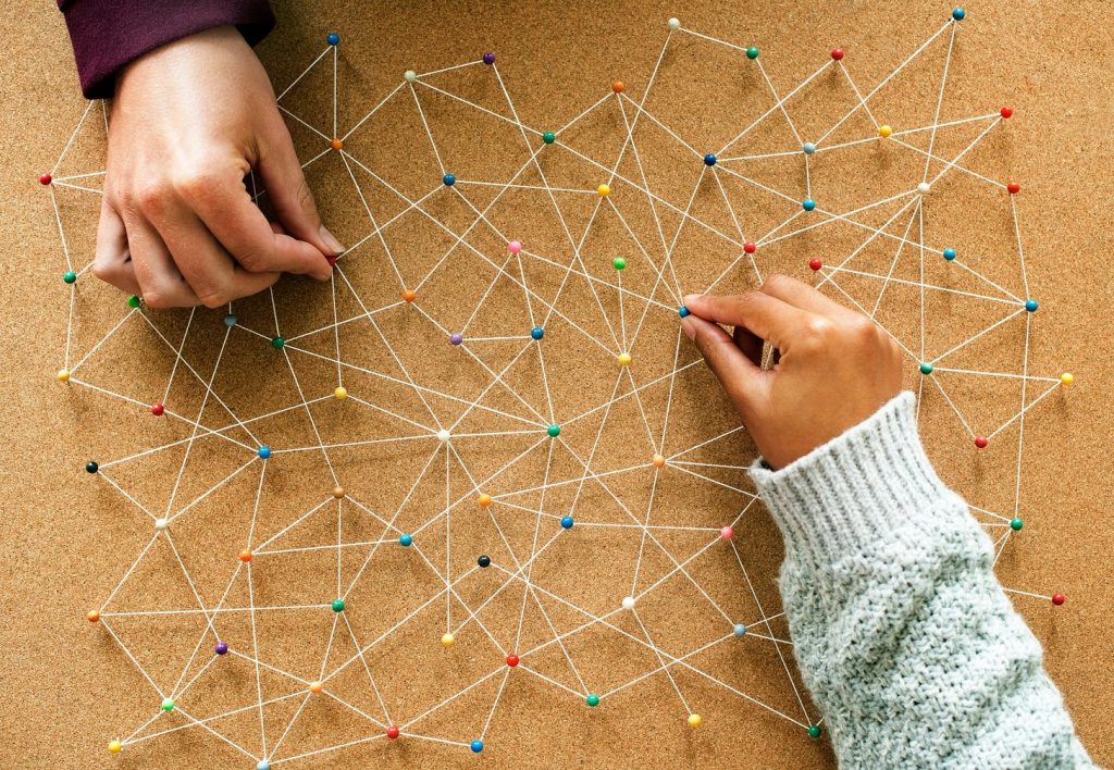 a cork board with pins and string